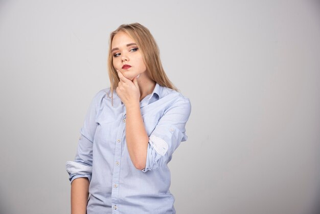 Woman thinking deeply about something on gray surface