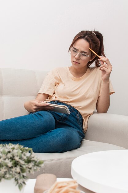 ノートブックを見ながら考える女