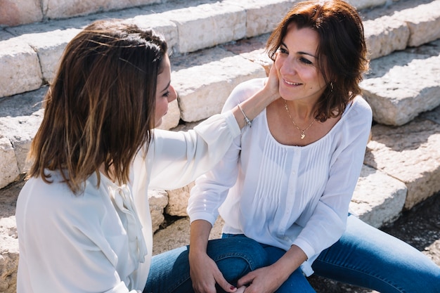 Woman touching cheek of woman