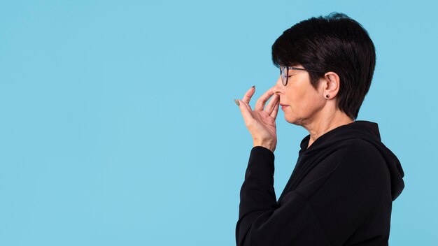 Free photo woman touching her nose with copy space