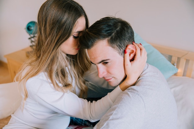 Woman touching man on bed