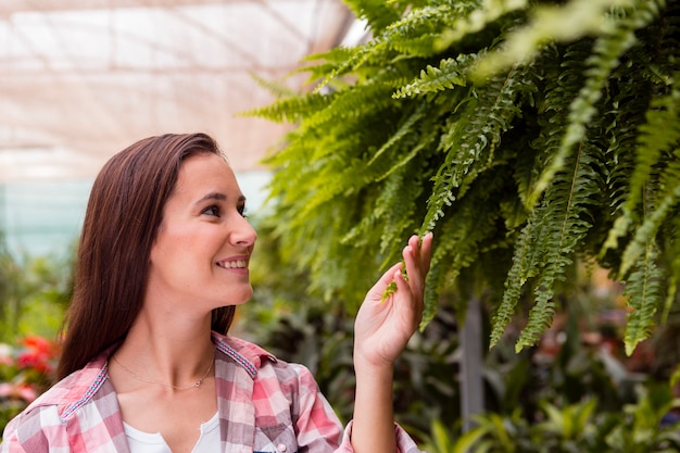 무료 사진 정원에서 식물을 만지는 여자