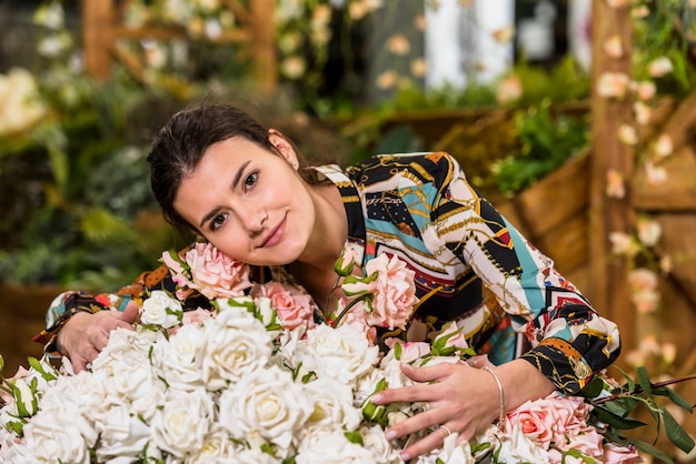 Free photo woman touching roses in green house