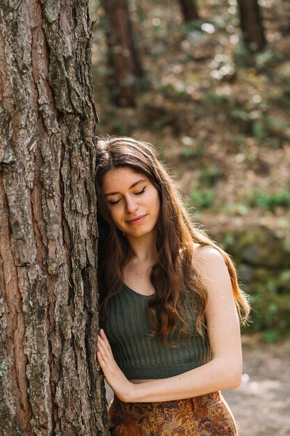 Woman touching tree with hand