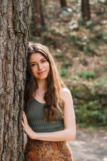 Woman touching tree with hand