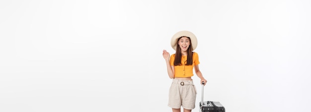分離されたエキサイティングなジェスチャーでスーツケースを持って立っている女性観光客全長幸せな若い女