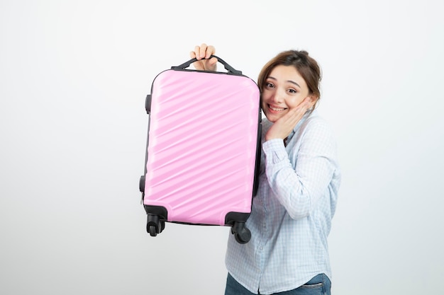 Woman tourist standing and holding pink travel suitcase . High quality photo