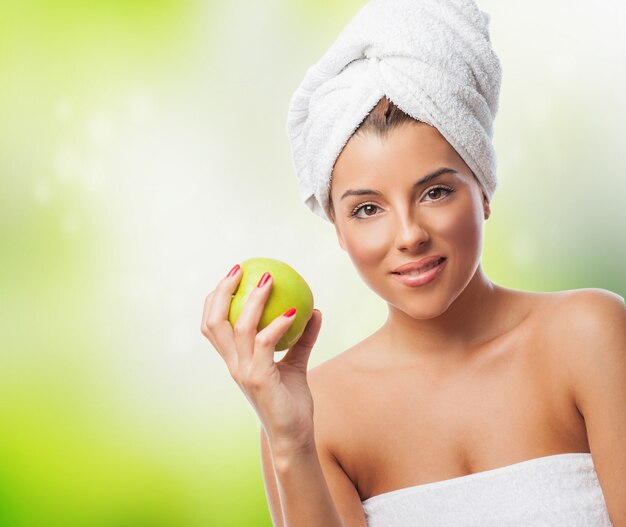 Woman in towel holding apple