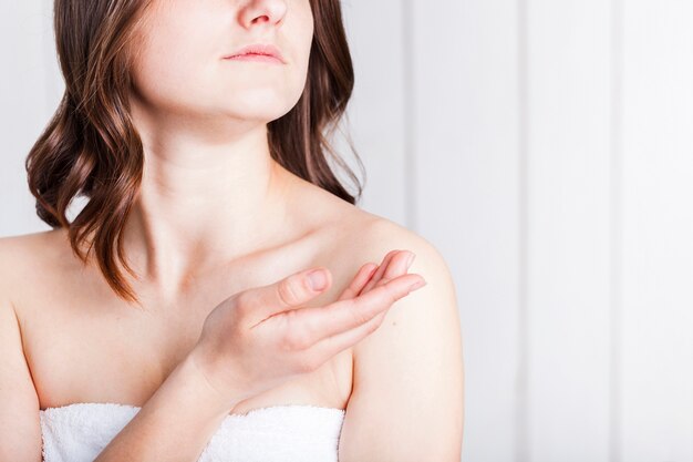 Woman in towel holding palm upwards