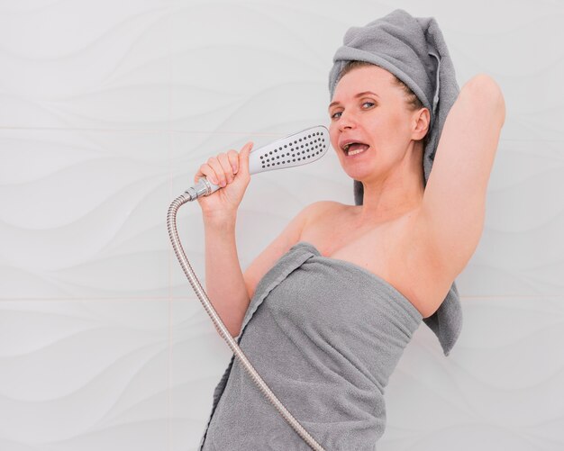 Woman in towels singing in the bathroom medium shot