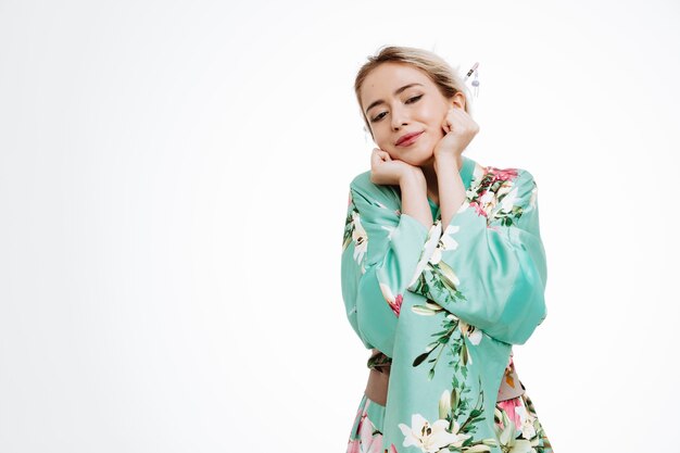 Woman in traditional japanese kimono looking happy and pleased touching her cheeks feeling pleasure on white