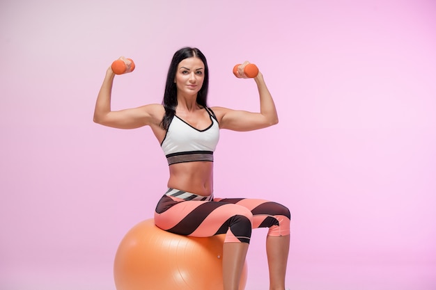 The woman training against pink studio