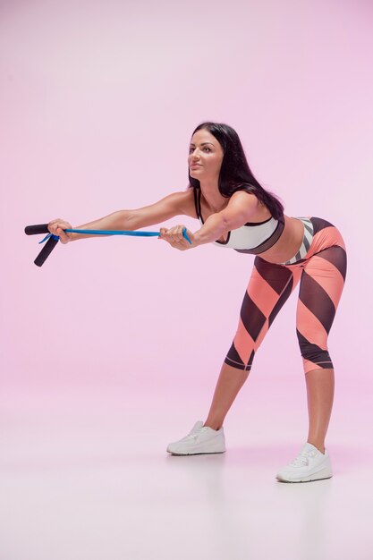 The woman training against pink  with jump rope