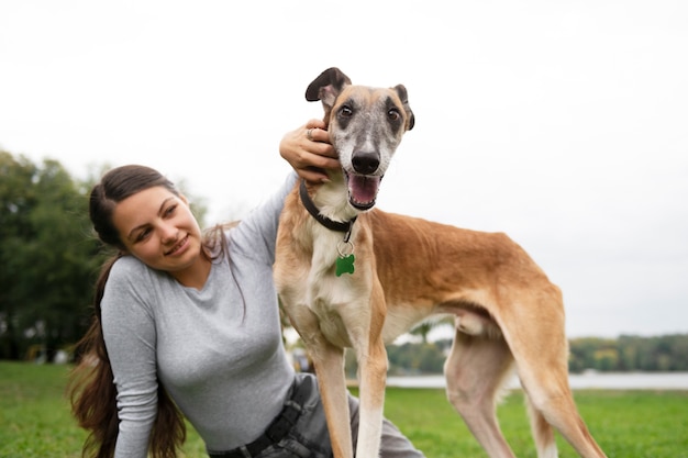 Vista frontale del cane di addestramento della donna all'aperto