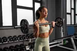 Free photo woman training for weightlifting in gym