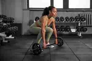 Free photo woman training for weightlifting in gym