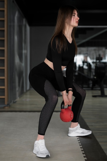 Женщина тренируется с поднятием тяжестей