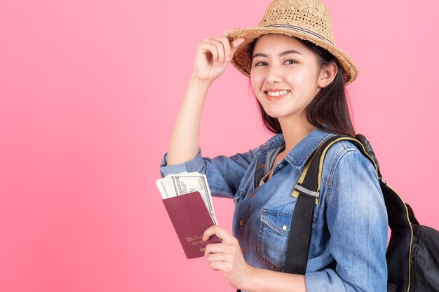 Free Photo woman traveler wearing straw hat is holding passport with banknote 