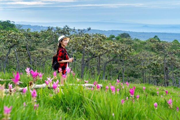 タイのクラシューフラワーフィールドでバックパックを楽しんでいる女性旅行者。旅行のコンセプト。