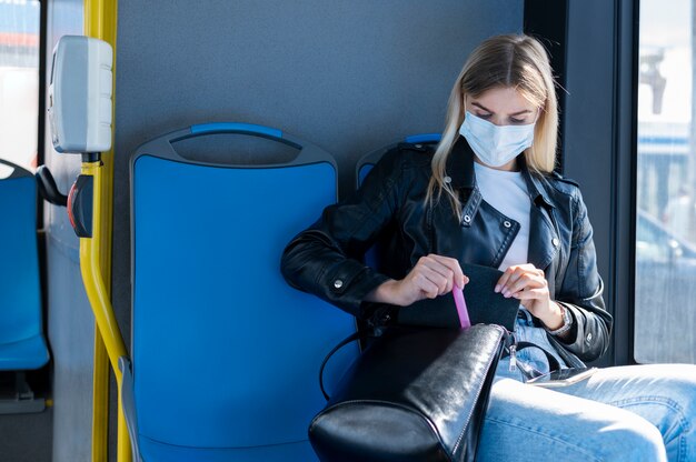 Woman traveling by public bus and wearing medical mask for protection