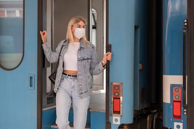 Woman traveling by train wearing medical mask for protection