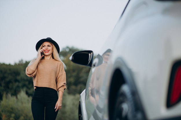 車で旅行し、電話を使用している女性