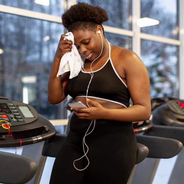 Free photo woman on treadmill using phone
