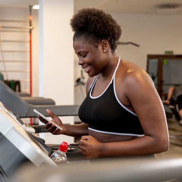 Woman on treadmill using phone