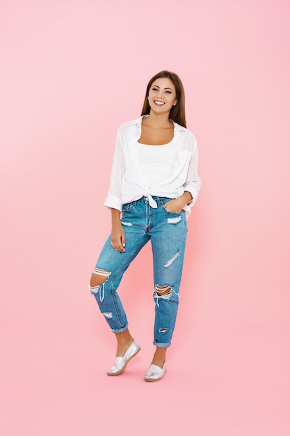 Woman in trendy spring outfit. Blue jeans and white shirt