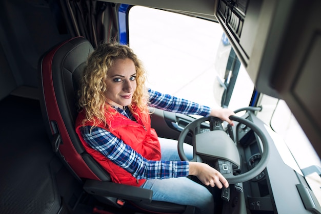 Woman trucker sitting in truck vehicle