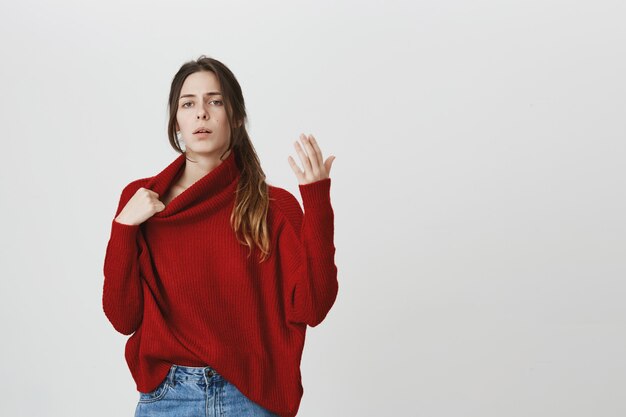 Woman trying cool down, feel hot in sweater