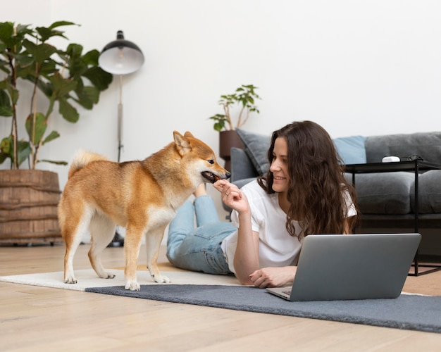 Foto gratuita donna che cerca di lavorare con il suo cane in giro