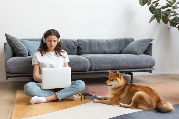 Free photo woman trying to work with her dog around