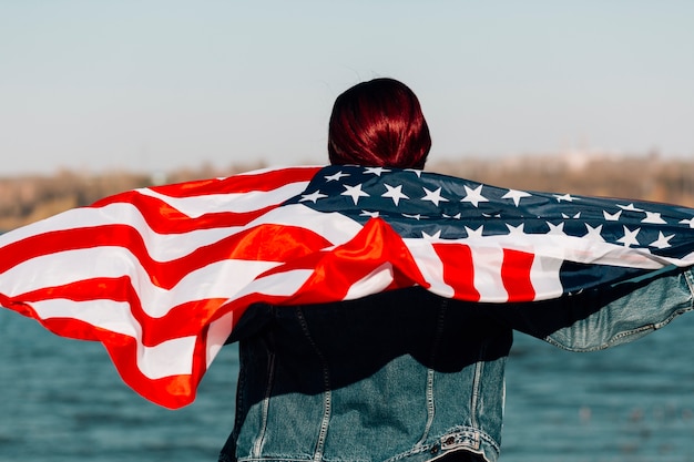 女性は立ってアメリカの国旗を保持して引き返した