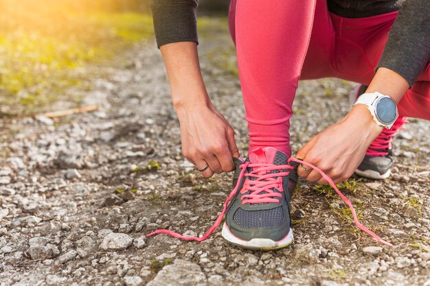 Woman tying her grey sneaker