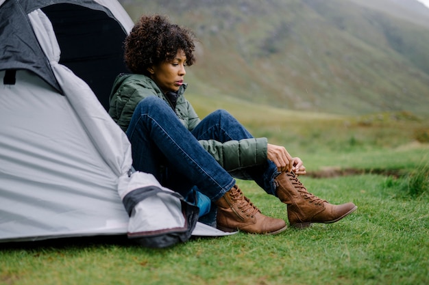 Бесплатное фото Женщина привязывает шнурки к ее палатке