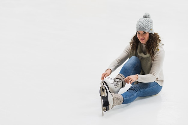 Woman tying laces on ice