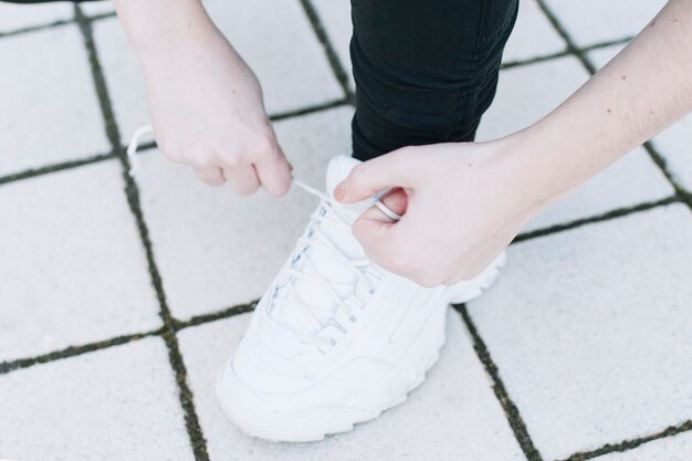 Woman tying laces on sneakers