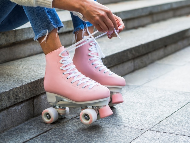 Woman tying shoelaces on roller skates with copy space