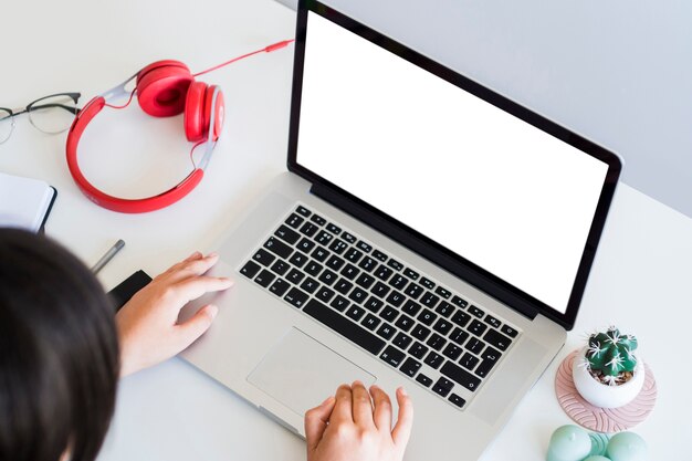 Woman typing on laptop on table with equipments