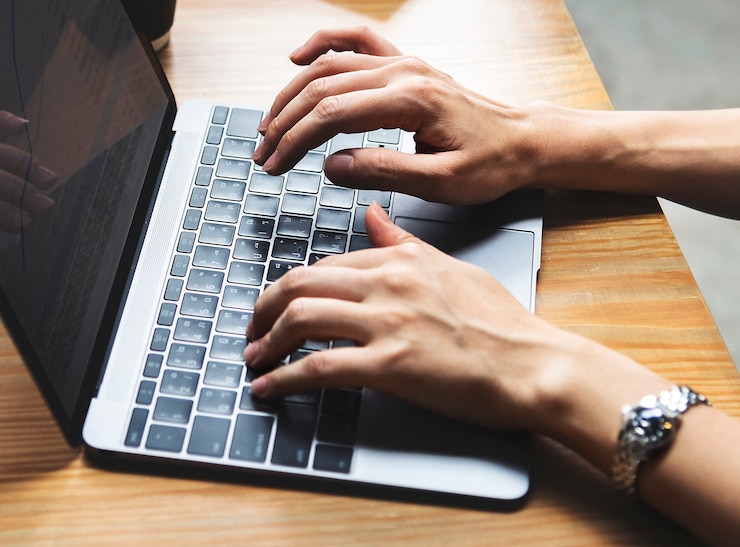 Free Photo woman typing on a laptop