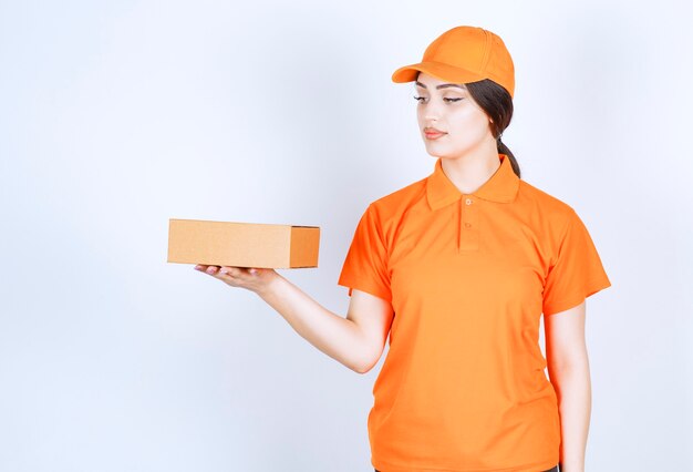 The woman in unishape holding package on white wall