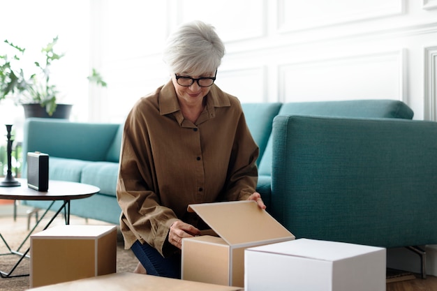 Free photo woman unpacking brown boxes in the living room