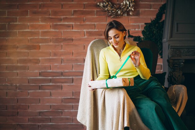 Woman unpacking presents by Christmas tree