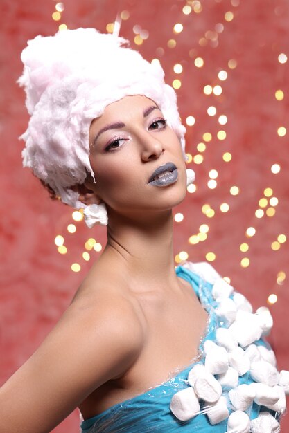 Woman in unusual dress made of marshmallow and wig of cotton candy