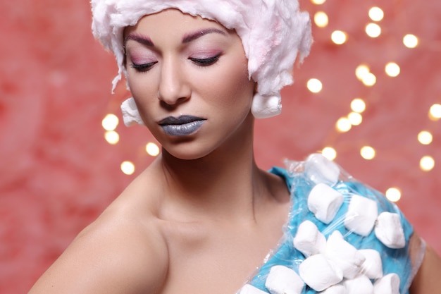 Woman in unusual dress made of marshmallow and wig of cotton candy