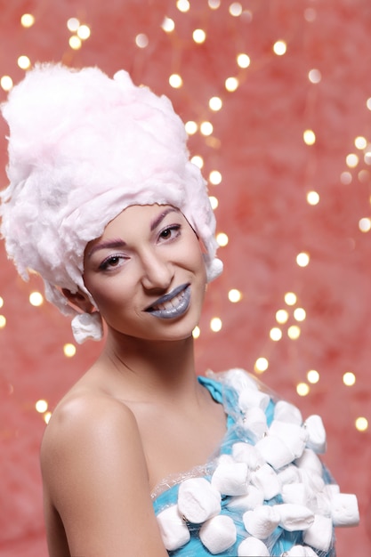 Woman in unusual dress made of marshmallow and wig of cotton candy