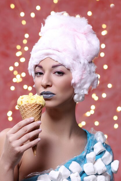 Woman in unusual dress made of marshmallow and wig of cotton candy