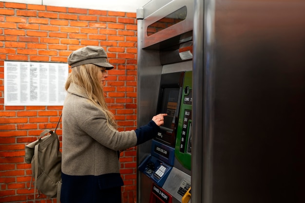 무료 사진 도시에서 지하철 카드 기계를 사용하는 여성