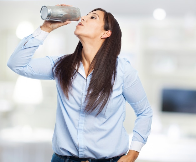 Free photo woman using an aluminum container to drink